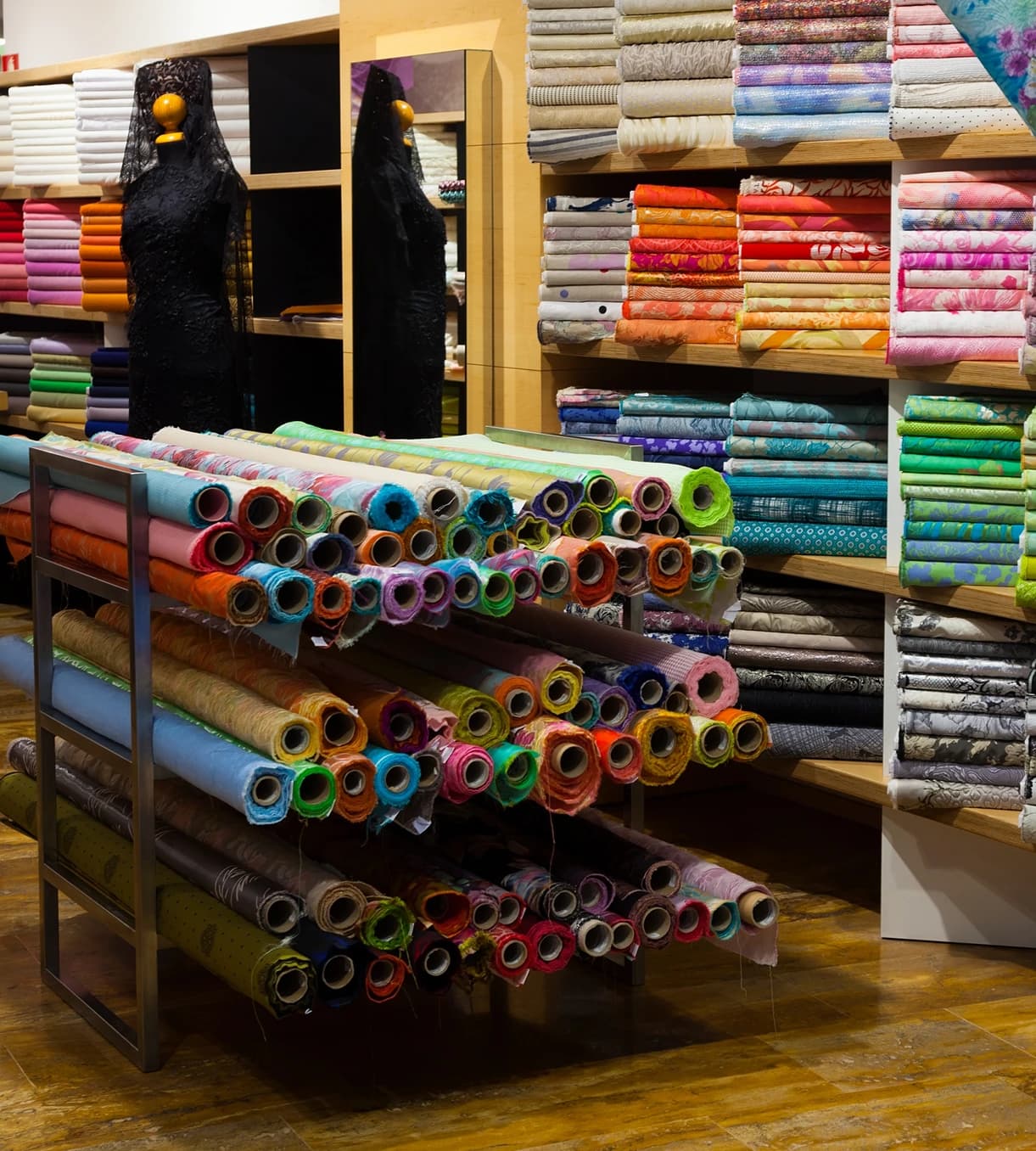 Shelves and racks of colourful fabric rolls in a textile store